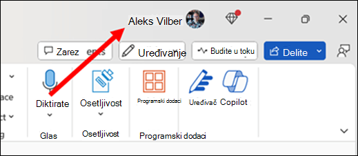 Slika sa crvenom strelicom koja pokazuje na trenutno primarno korisničko ime koje se nalazi na naslovnoj traci aplikacije u gornjem desnom uglu prozora.